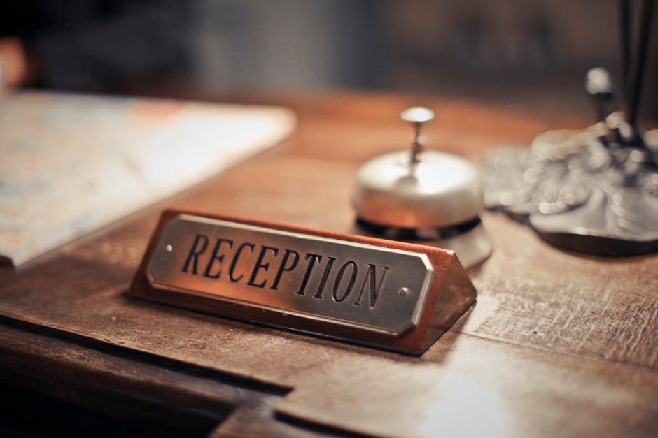 Close-up of a hotel reception desk showcasing a service bell and signage, emphasizing hospitality