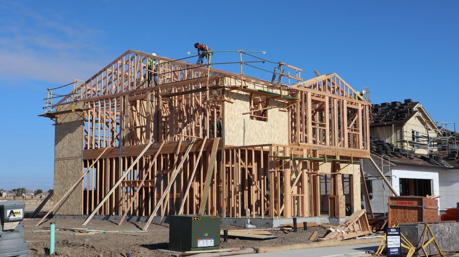 Wood framing of a new house being constructed under a clear blue sky in Sacramento, California.